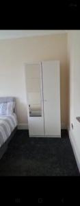 a white cabinet in a bedroom with a bed at 4 Goodman Lodge & 7 goodman Lodge in Thornton Heath