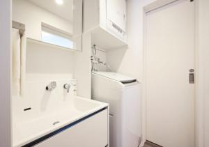 bagno bianco con lavandino e servizi igienici di 波の音テラス富津 a Futtsu