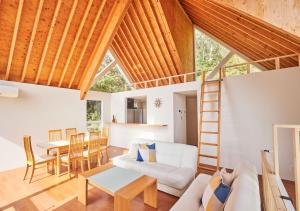 a living room with a white couch and a wooden ceiling at 波の音テラス富津 in Futtsu