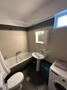 a bathroom with a toilet and a sink and a tub at Aiolos Seaside Villa in Kanali