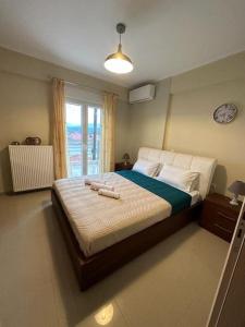 1 dormitorio con 1 cama grande y ventana en Aiolos Seaside Villa, en Kanali