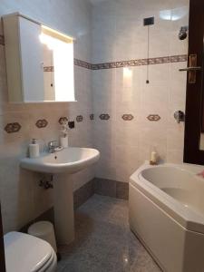 Cozy Home في سوماكامبانا: حمام مع حوض وحوض استحمام ومرحاض