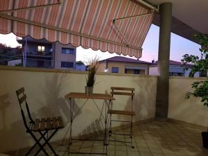 Cozy Home في سوماكامبانا: فناء فيه كرسيين وطاولة ومظلة