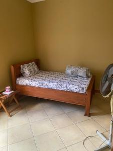 1 dormitorio con cama de madera en una habitación en Hein apartment en Arusha