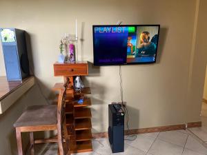 a television hanging on a wall with a stair case and a television at Hein apartment in Arusha