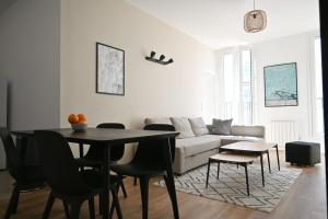 ein Wohnzimmer mit einem Tisch und einem Sofa in der Unterkunft Magnifique appartement T4, plage des Catalans in Marseille