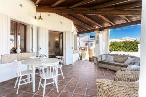 a patio with a table and chairs and a couch at Villa Regina Margherita in Olbia