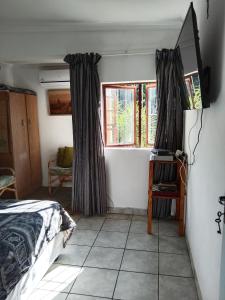 une chambre avec un lit et deux fenêtres dans l'établissement Jacobs Cottage by the Ocean, à Port Shepstone 4 autres photos