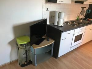 eine Küche mit einem Schreibtisch und einem Computer darauf in der Unterkunft (2) Spiekeroog in Dornum