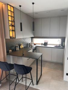 a kitchen with white cabinets and a table and chairs at Apartment over two floors in Kaunas