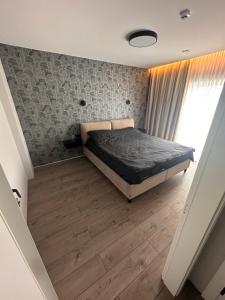 a bedroom with a bed and a wooden floor at Apartment over two floors in Kaunas