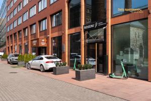 biały samochód zaparkowany przed budynkiem w obiekcie Luxury Suites - Rotermann City w Tallinnie