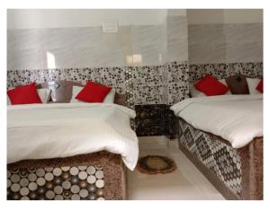 two beds in a room with red pillows on them at Hotel Prem Vilas Paradise By WB Inn in Pātolī