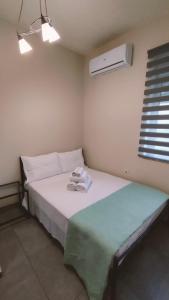 a small bedroom with a bed and a air conditioner at COSY APARTMENTS in Chania