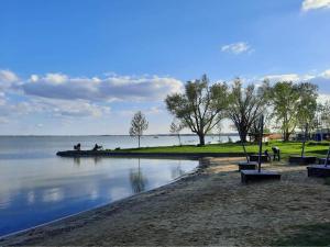 a park with benches and a body of water at Petit Paul Apartman in Keszthely