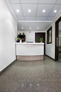 an office lobby with a reception desk with plants at Palm Stay - Studios & Rooms in Jaipur