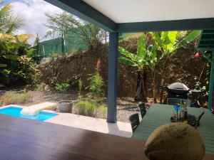 un patio con una mesa y una piscina en Villa Jalna Zamana appartement piscine privée jardin, en Les Trois-Îlets