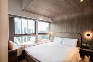 a bedroom with a large bed and a large window at Hillwood House Hotel in Hong Kong