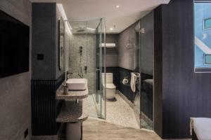 a bathroom with a shower and a toilet and a sink at Hillwood House Hotel in Hong Kong