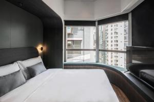 a bedroom with a bed and a large window at Hillwood House Hotel in Hong Kong