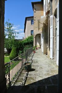 une allée vide avec une clôture et un bâtiment dans l'établissement Maison d'hôtes - Hôtel particulier de Jerphanion Cambacérès, au Puy-en-Velay