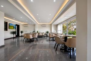 a restaurant with tables and chairs in a room at Palm Stay - Studios & Rooms in Jaipur