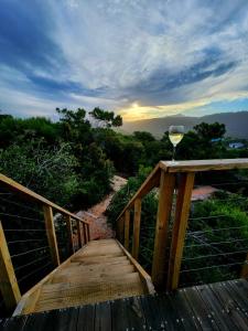 a glass of wine sitting on a wooden bridge at Villa Keys in Wilderness