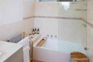 a bathroom with a tub with a glass shower at Coola studio in Mallacoota