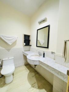 La salle de bains est pourvue de toilettes et d'un lavabo. dans l'établissement BedChambers Serviced Apartments, Cyberpark, à Gurgaon
