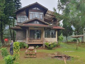 a man standing in front of a house at Aubrey Villa Ciwidey in Pengalongan