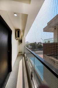 a balcony with a view of a swimming pool at Palm Stay - Studios & Rooms in Jaipur