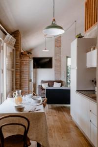 een keuken en een woonkamer met een tafel en een bank bij Roero House in Magliano Alfieri