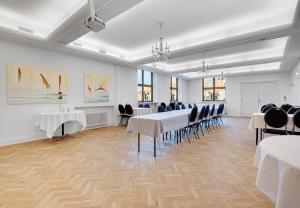 uma sala de conferências com mesas e cadeiras brancas em Hotel Phønix Brønderslev em Bronderslev