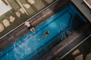 an overhead view of a man swimming in a swimming pool at Tropik Resort Lombok in Selong Belanak