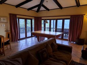 een woonkamer met een bank en een tafel bij Da Gama Lake Cottages - Coral Tree and Cormorant Cottages in White River