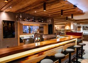 eine Bar mit einer Holztheke in einem Zimmer in der Unterkunft Hotel Lohningerhof in Maria Alm am Steinernen Meer + 37 Fotos