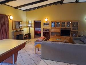 een woonkamer met een bank en een tafel bij Da Gama Lake Cottages - Coral Tree and Cormorant Cottages in White River