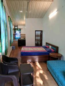 ビムタルにあるSunshine yellow Jungle cottageのベッドルーム1室(ベッド2台、テーブル、椅子付)