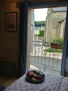 un plato de comida en una mesa frente a una ventana en La Bienheureuse Maison, vue sur le Château de Villandry en Villandry