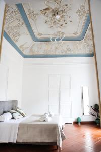 una camera con un soffitto a cassettoni e un letto di B&B Palazzo Bruca Catania a Catania