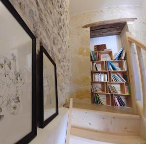 una stanza con una libreria e uno specchio di La Bienheureuse Maison, vue sur le Château de Villandry a Villandry