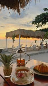 a cup of coffee and a croissant on a table at 7SEAS Cottages in Gili Islands