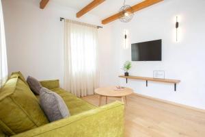 a living room with a green couch and a table at Angestrale Traditional Residence in Lefkada Town