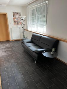 a living room with a black couch and a table at Hotel zur Wasserburg in Kerpen