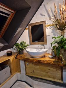 uma casa de banho com um lavatório e um espelho num balcão em La Parenthèse em Sambin