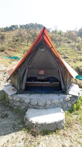 a tent that is sitting in a field at Crazy Cub Camp in Bīr