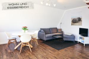 sala de estar con mesa y sofá en Ferienwohnung Maisonette in ruhiger und zentraler Lage mit Parkplatz, en Büsum