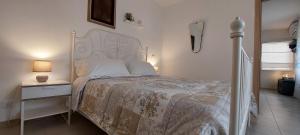 a bedroom with a bed with a white bedspread and a night stand at Dimora Carucci in Noci +41 photos