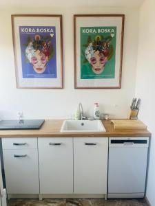 a bathroom with a sink and two posters on the wall at Apartament na Spółdzielczej in Radzyń Podlaski