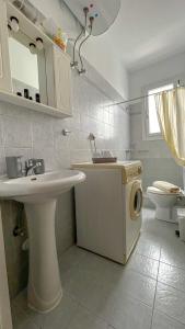 a bathroom with a sink and a washing machine at CENTRAL APARTMENTs in Ermoupoli